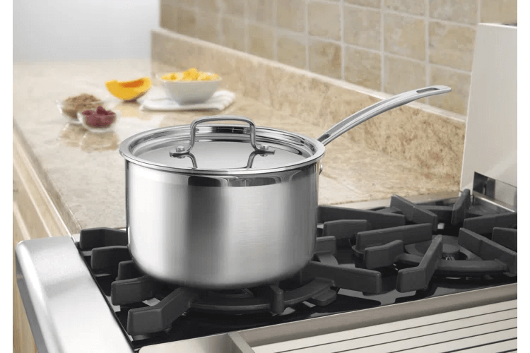 A sleek stainless steel saucepan with lid sits on a gas stove