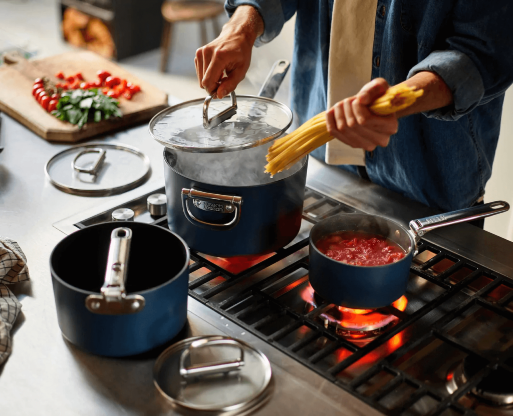 A man putting spaghetti in a saucepan